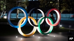 Los anillos olímpicos frente al nuevo Estadio Nacional de Tokio. 